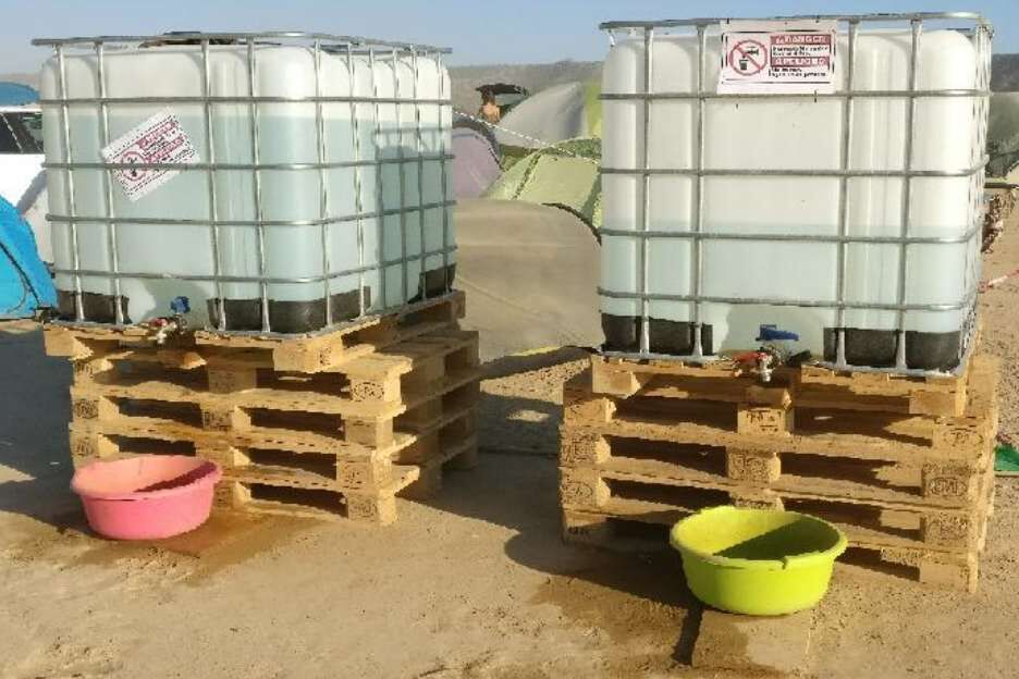 A barrio shower setup with shower bags on a pulley