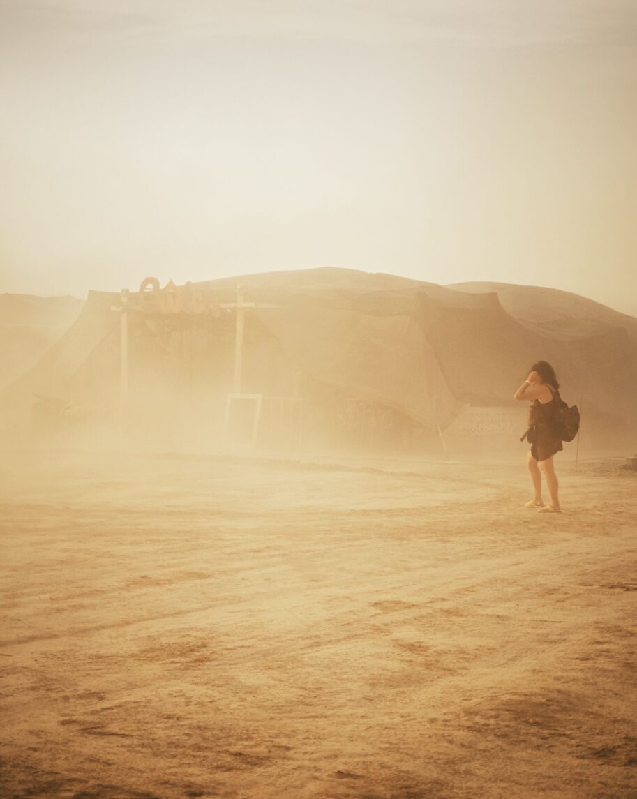 A lone figure walks across the hazy Monegros desert